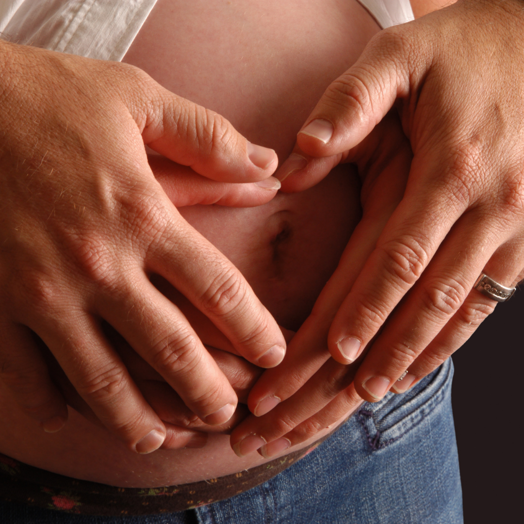 Hænder på gravid mave